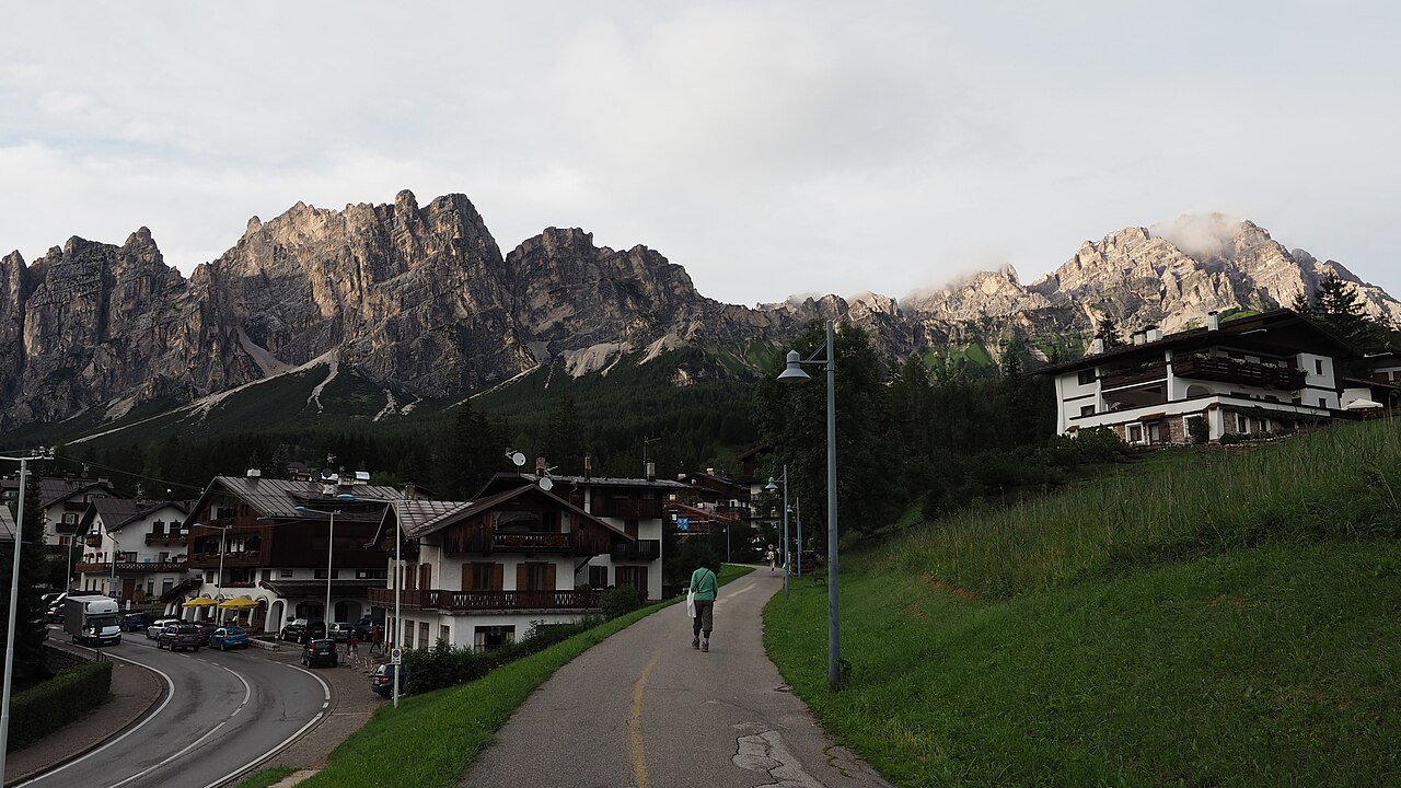 Una sera di luglio a Cortina d'Ampezzo: case in legno, la passeggiata pedonale e le cime del Pomagagnon e del Cristallo sullo sfondo