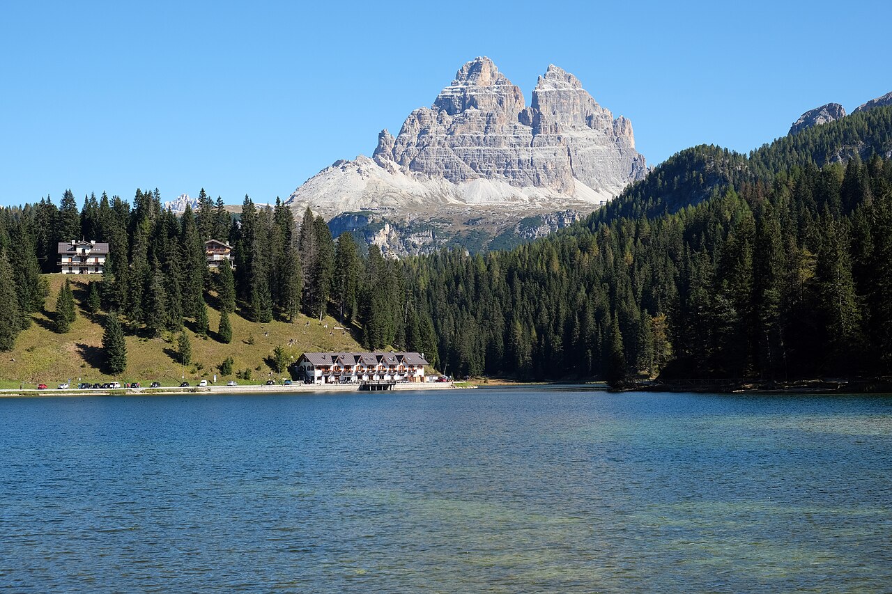 Il lago di Misurina con gli alberghi sulla riva, il bosco di abeti e le Tre Cime di Lavaredo sullo sfondo